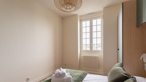 A hotel room with a bed, a window, and a radiator. - Ker Marlyne - Proche du Port (Dinard)