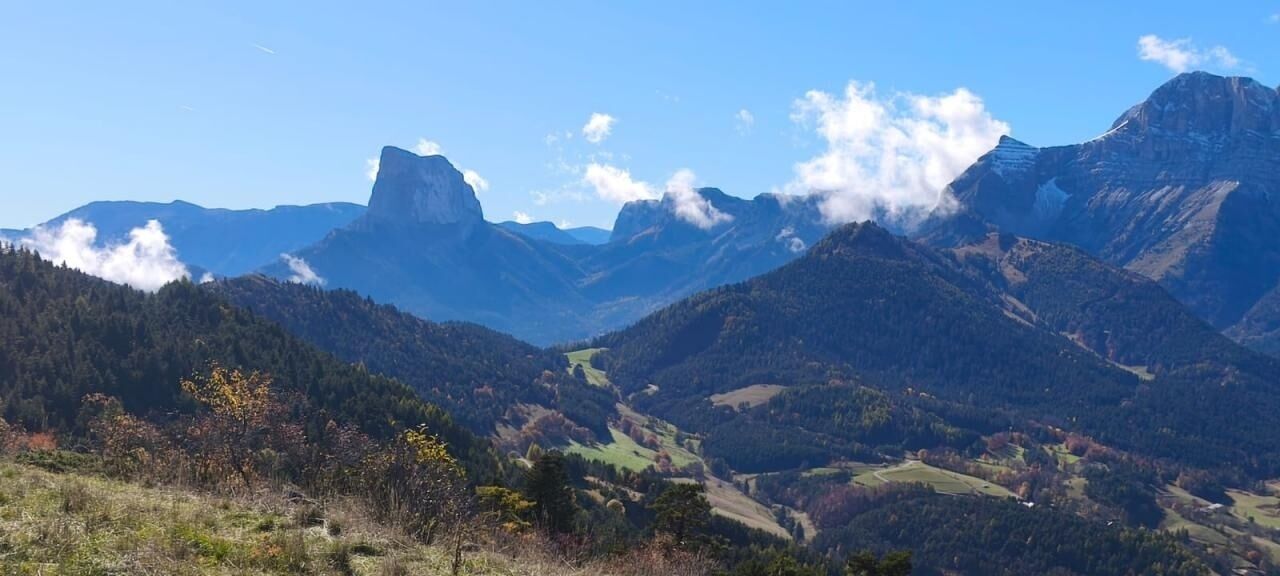 Paisagem montanhosa com um pico imponente e um vale.