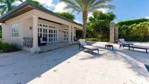 A house with a covered patio, a pool, and lounge chairs. - Villa Zaphira (Puerto Plata)