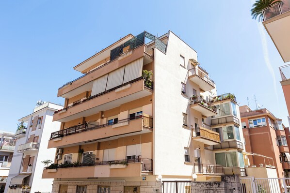 A multi-story residential building with balconies, air conditioning units, and a visible garage entrance. - Mistrà 18 Vatican House * 10 feet Metro A *parking (Roma)