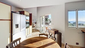 Uma cozinha moderna com área de jantar, vista para o exterior e uma janela grande.
