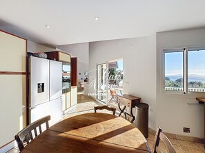 Eine moderne Küche mit Essbereich, Blick ins Freie und einem großen Fenster.