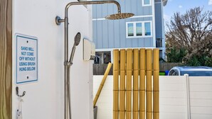 A shower with a sign indicating sand will not come off without using a brush hung below. - The CODtage is amazing! 60 steps from beach, 2.5 blks to boardwalk! (Carolina Beach)