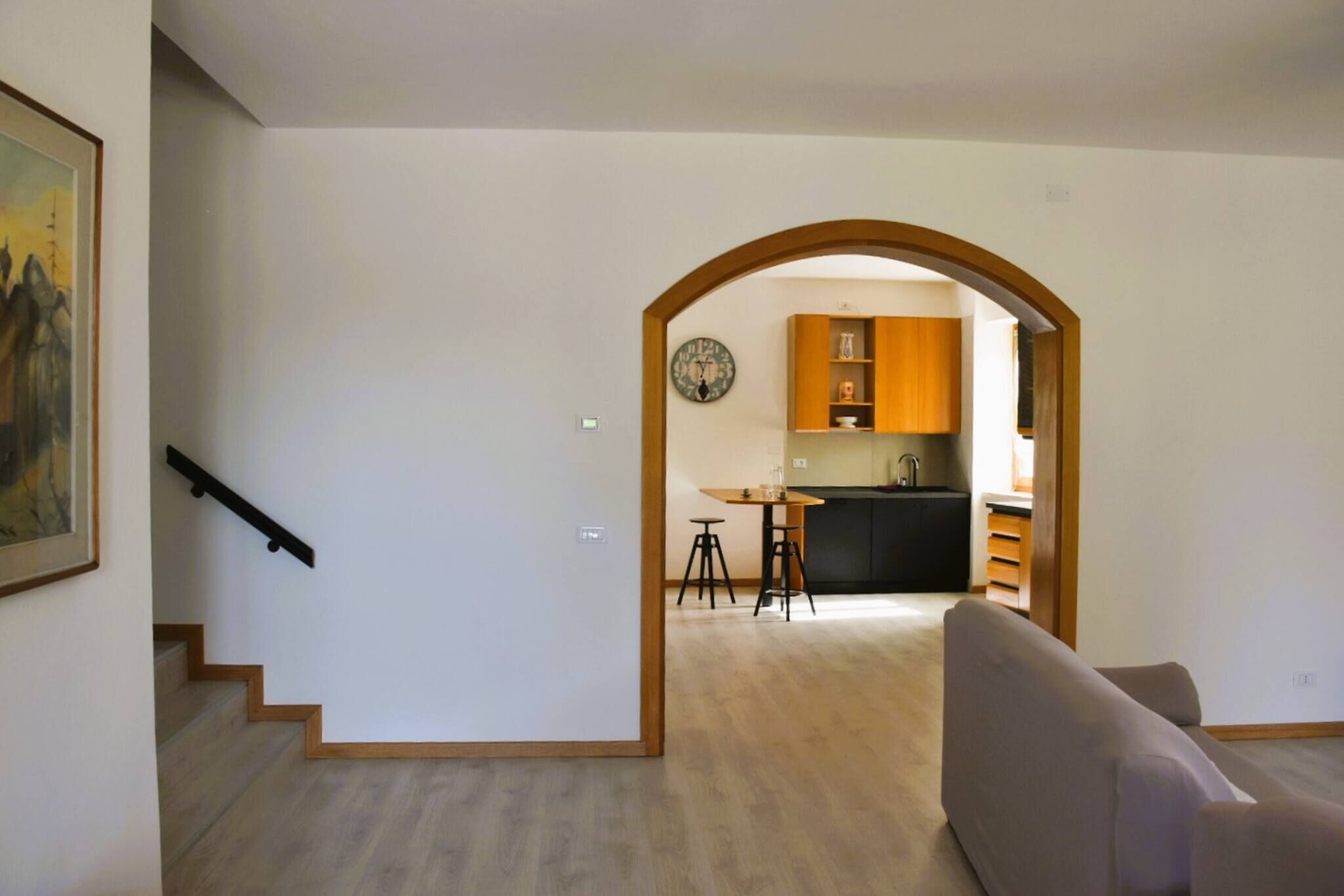 Un intérieur moderne comprenant un escalier, un coin repas et une cuisine.