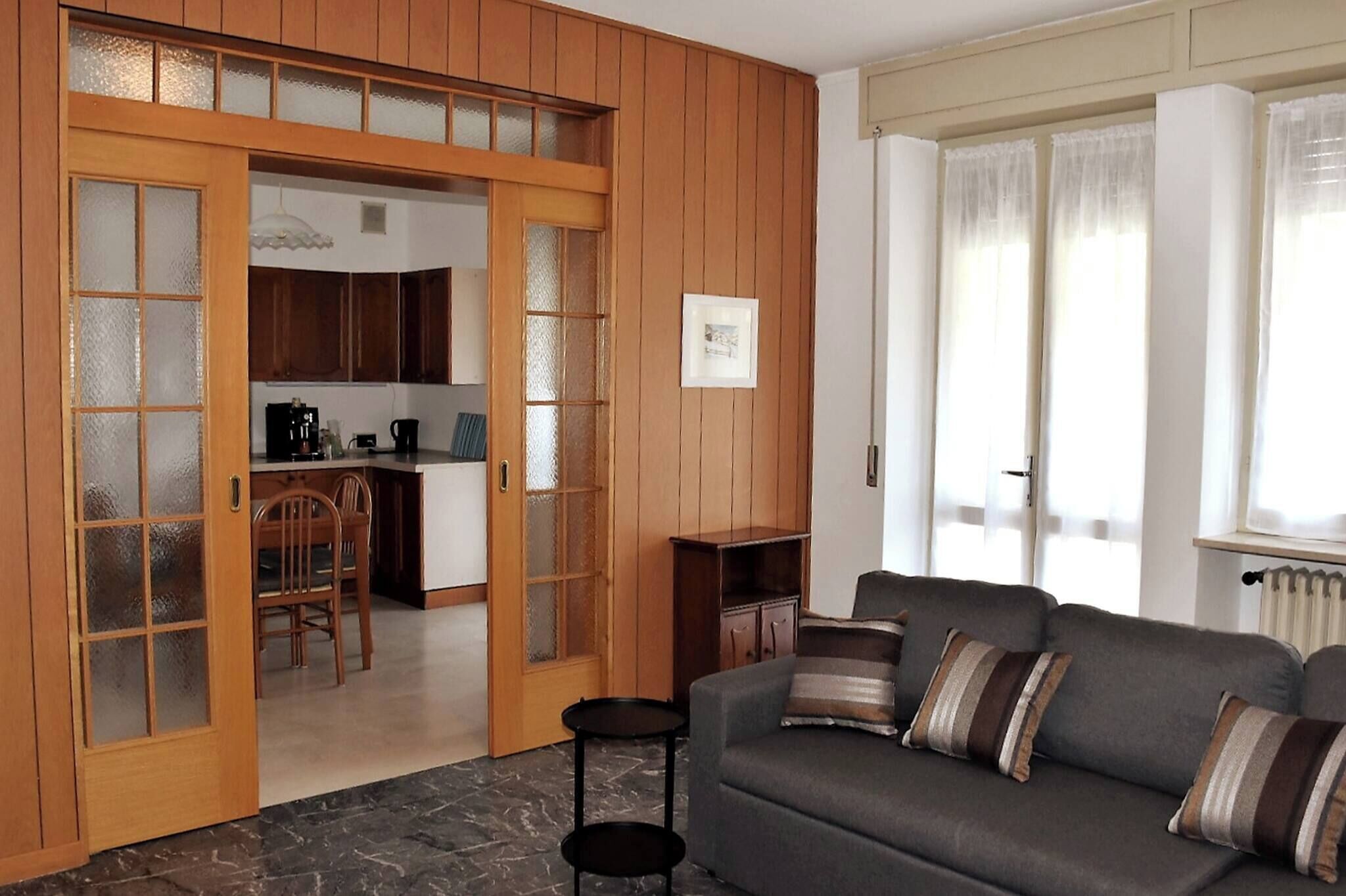 A living room with a sofa, a coffee table, and a dining area with chairs and a table.