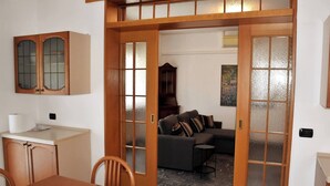Una habitación con una mesa de comedor, sillas, un sofá y un armario.