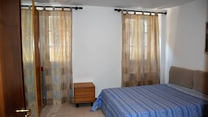 Ein Schlafzimmer mit einem Bett, einem Nachttisch aus Holz und einer Tür.