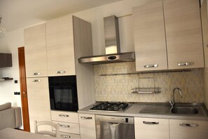 A modern kitchen with stainless steel appliances, a dishwasher, and a built-in oven. - Apollonia House - Holiday Rental (Garda)