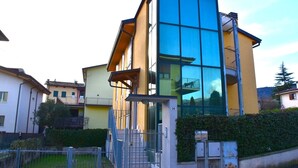 Un edifici modern de dues plantes amb grans finestres de vidre i façana groga.