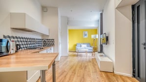 Une cuisine moderne dotée d’un plan de travail en bois, d’un four à micro-ondes encastré et d’une machine à café.