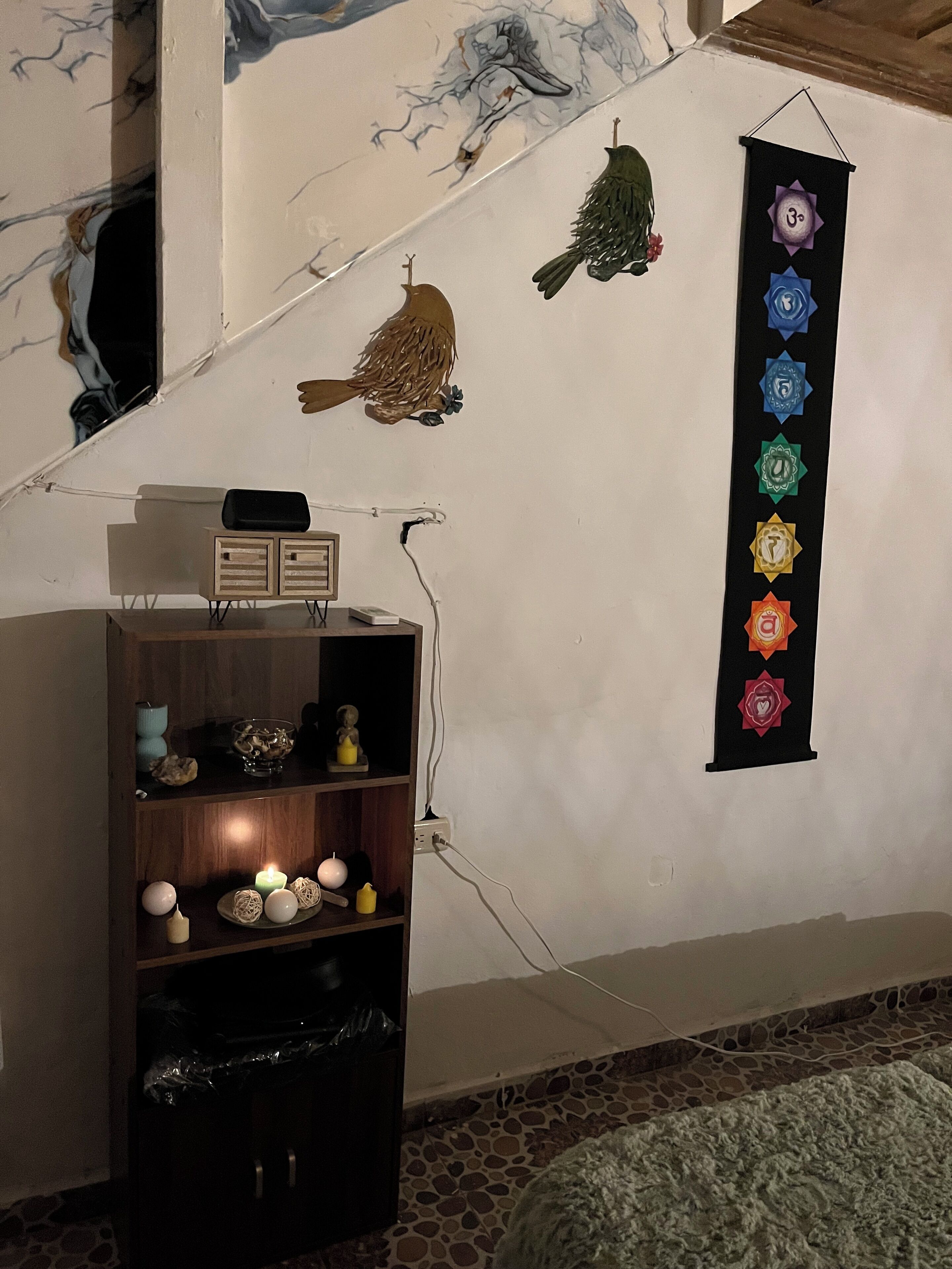 Una habitación con estante en la pared, toma corrientes y un adorno mural con símbolos.