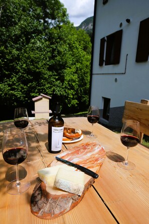 Ein Holztisch mit einer Weinflasche, Gläsern, Käse und einem Holzbrett.