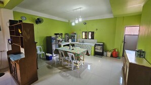 A compact kitchen with a dining table, chairs, a refrigerator, a stove, and a sink.