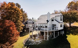 Ein großes Haus mit überdachter Terrasse, zahlreichen Fenstern und Schornstein.