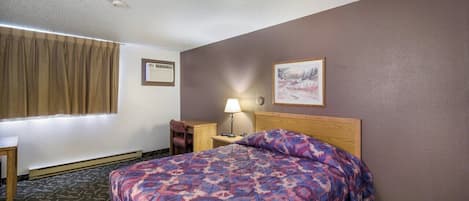 A hotel room with a bed, a nightstand, a lamp, a window with curtains, and a painting on the wall.
