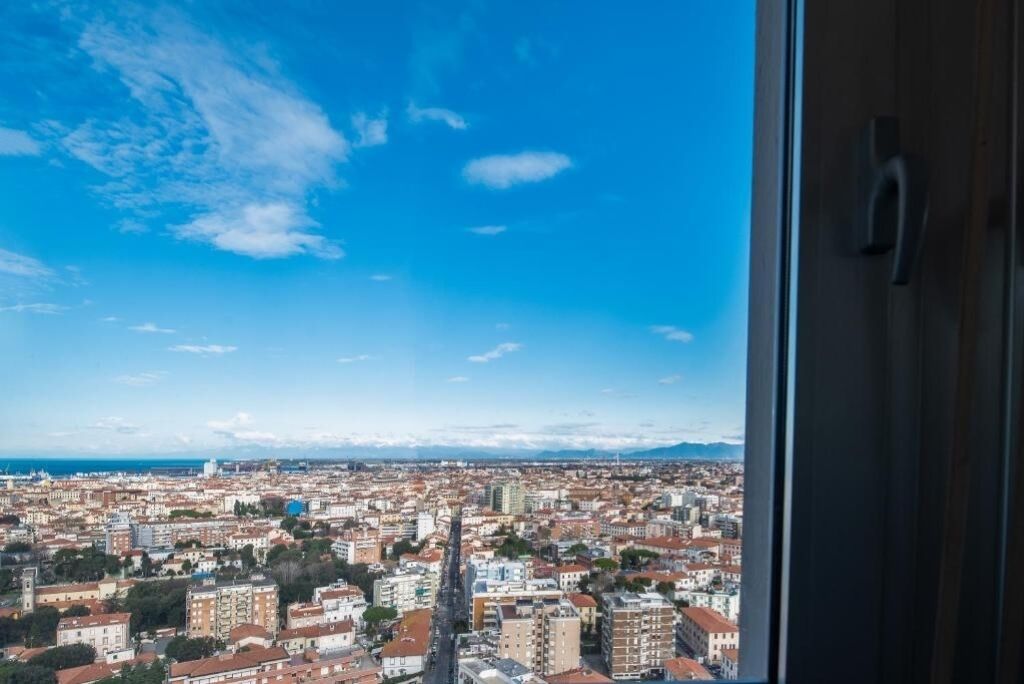 Une vue sur la ville, prise depuis une fenêtre, avec un ciel dégagé.