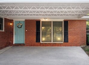 A brick house with a teal door, two windows with shutters, and a covered porch. - Clean, Quiet Private Suite w/ Hot Tub • Near Fort Benning/Midtown (Columbus)