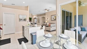 A modern apartment with a kitchen, dining area, and living room. - South Facing Pool 4 Bedroom 3 Bath Villa - Just Minutes from Disney World! (Kissimmee)