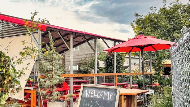 A patio area with a chalkboard sign welcoming guests and offering table service. - Spacious private whole guest house in NE Portland! (Portland)