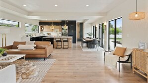 Un salon moderne comprenant un canapé, une table basse et un coin repas avec une table et des chaises.