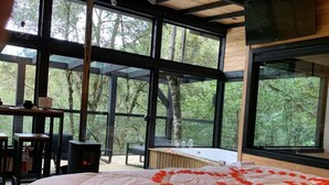 Quarto com uma cama grande, uma escrivaninha de madeira e lareira.