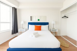 A hotel room with a large bed, two bedside tables, a wardrobe, and a window with curtains. - Luxury 1-Bedroom- Yonge & Sheppard-Direct Subway (Toronto)