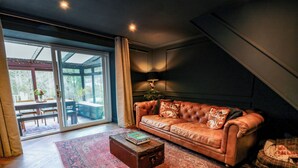A modern living room with a leather sofa, a coffee table, and a large window with a view of the outdoors. - 7 Brewery Pool (Newton Stewart)