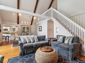 A spacious living area with a modern staircase, a sofa set, and a kitchen in the background. - Waterfront 4BR House w/ Private Dock | Nr Beaches! (Bethany Beach)