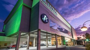 Un hôtel moderne, reconnaissable à son grand panneau indiquant « ACTUAL », à ses larges fenêtres et à son parking couvert.