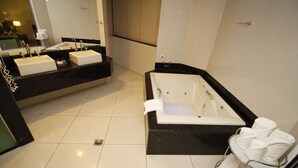 Une salle de bain moderne avec une grande baignoire, deux lavabos et un porte-serviettes.