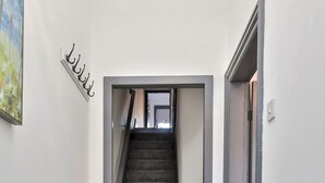 A narrow hallway with a carpeted staircase leading to a door. - Chesterfield House, 7BR, Blackpool (Blackpool)