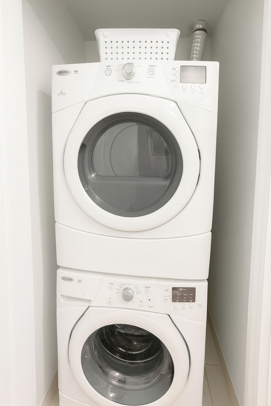 Een wasmachine en droger boven elkaar in een wasserij.