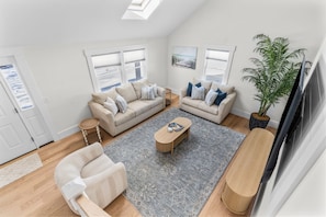 A modern living room with a sectional sofa, a coffee table, and a large potted plant.