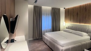 A modern bedroom with a large bed, a bedside table, a mirror, and a ceiling light fixture. - Bella Vista Lake Villa • Jacuzzi • Balcony • Perfect for Groups (Memlisht)