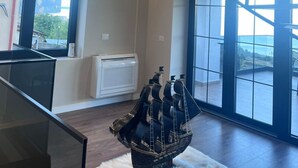 A spacious room with a large window, a white air conditioning unit, and a unique hanging light fixture. - Bella Vista Lake Villa • Jacuzzi • Balcony • Perfect for Groups (Memlisht)