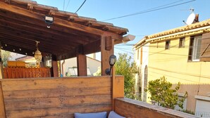 Ein Sitzbereich im Freien mit Holzmöbeln, einer Couch und einem Holztisch.