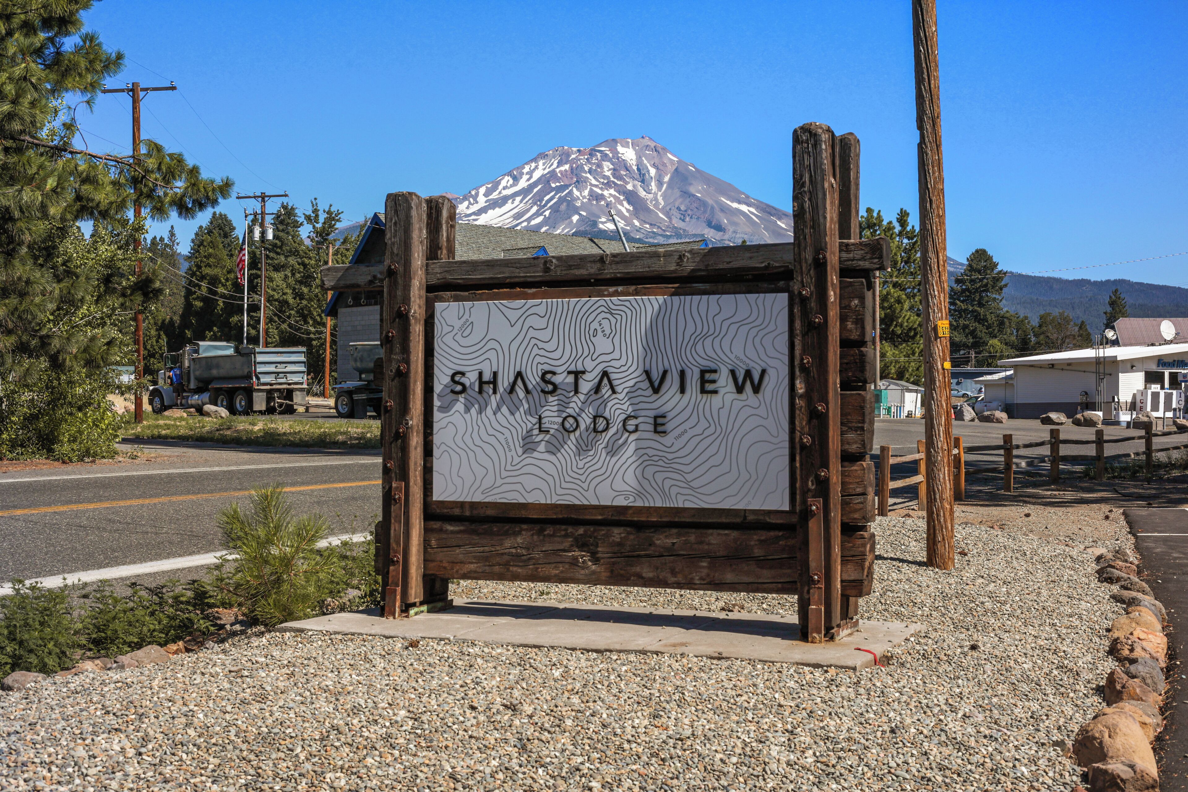A sign for Shasta View Lodge with a mountain in the background.