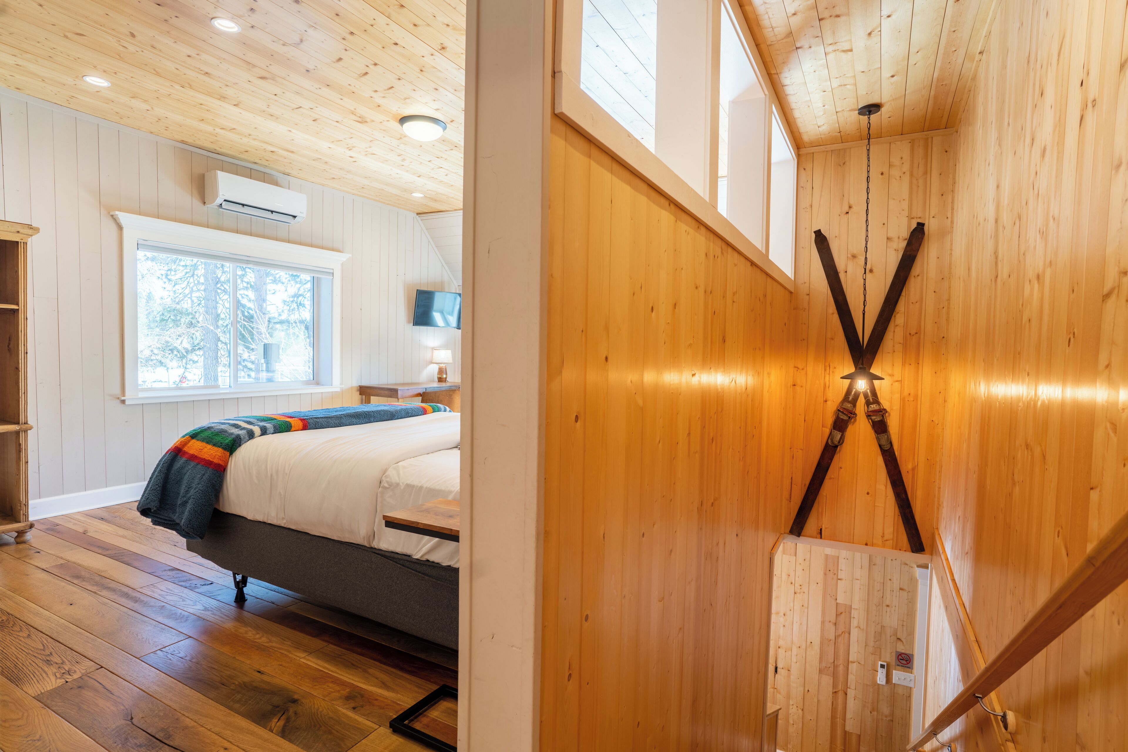 Une chambre à coucher avec un lit, une fenêtre et un plafond en bois.
