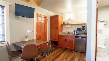 A compact kitchen with wooden cabinets, a built-in microwave, and a dishwasher.