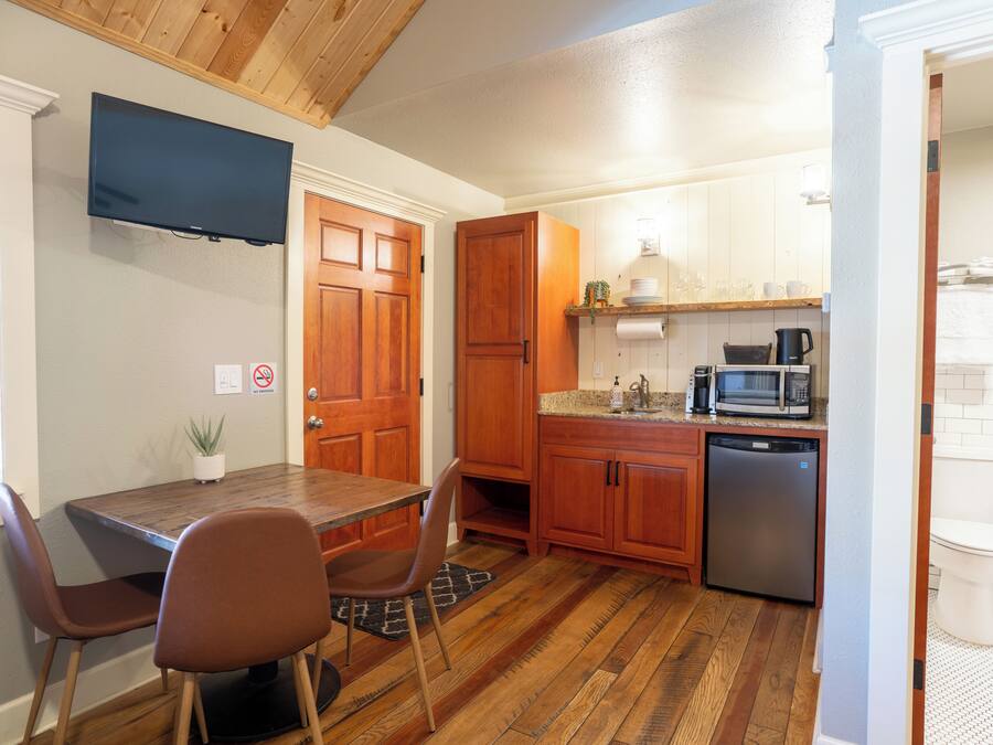 A compact kitchen with wooden cabinets, a built-in microwave, and a dishwasher.