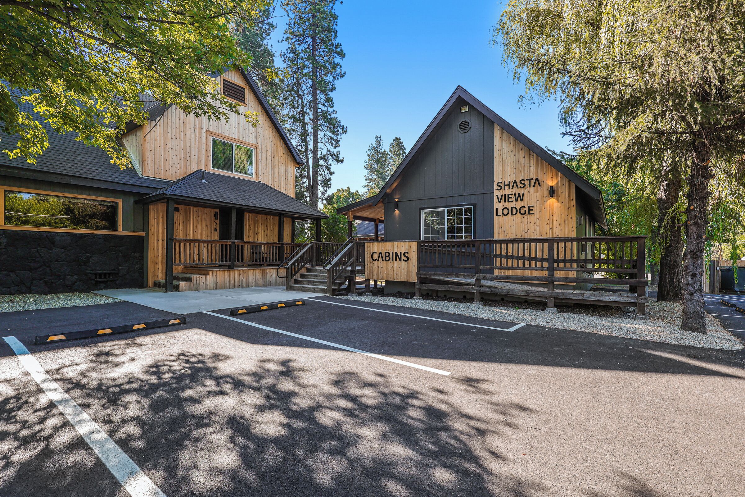 A cabin-style lodge with a wooden exterior, a covered deck, and a staircase leading to the cabins.