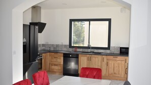 Une cuisine moderne avec des meubles en bois, un lave-vaisselle noir et une fenêtre donnant sur l’extérieur.
