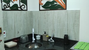 Eine Küche mit Spüle, Kaffeemaschine und Toaster. Darüber befinden sich zwei dekorative Wandelemente.