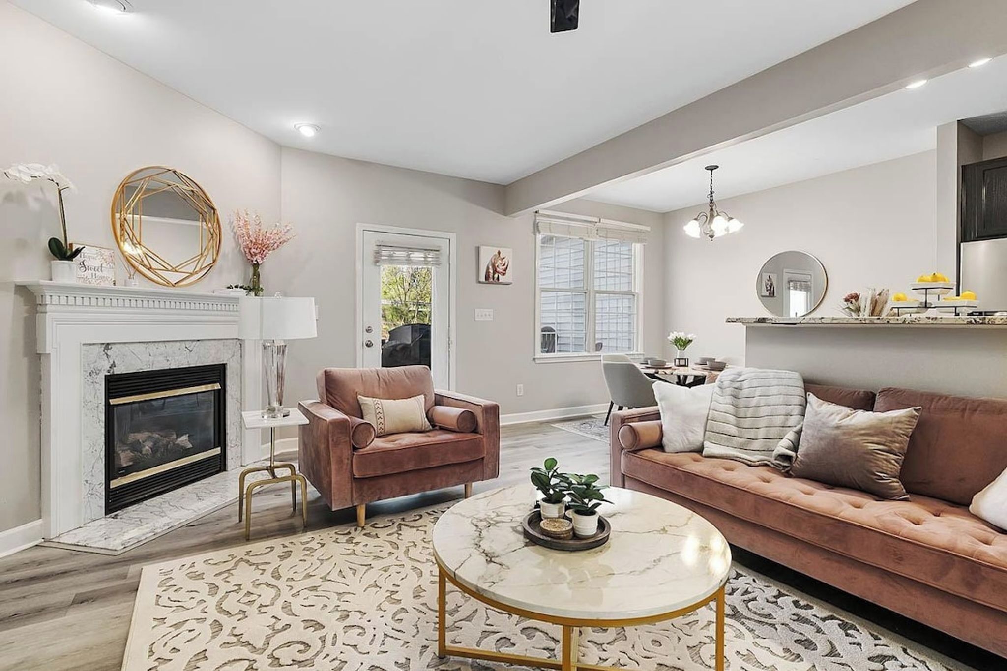 A living room with a fireplace, two sofas, a coffee table, and a patterned rug.