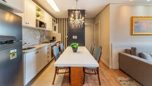 Une cuisine moderne avec un coin repas, un lustre et un canapé.