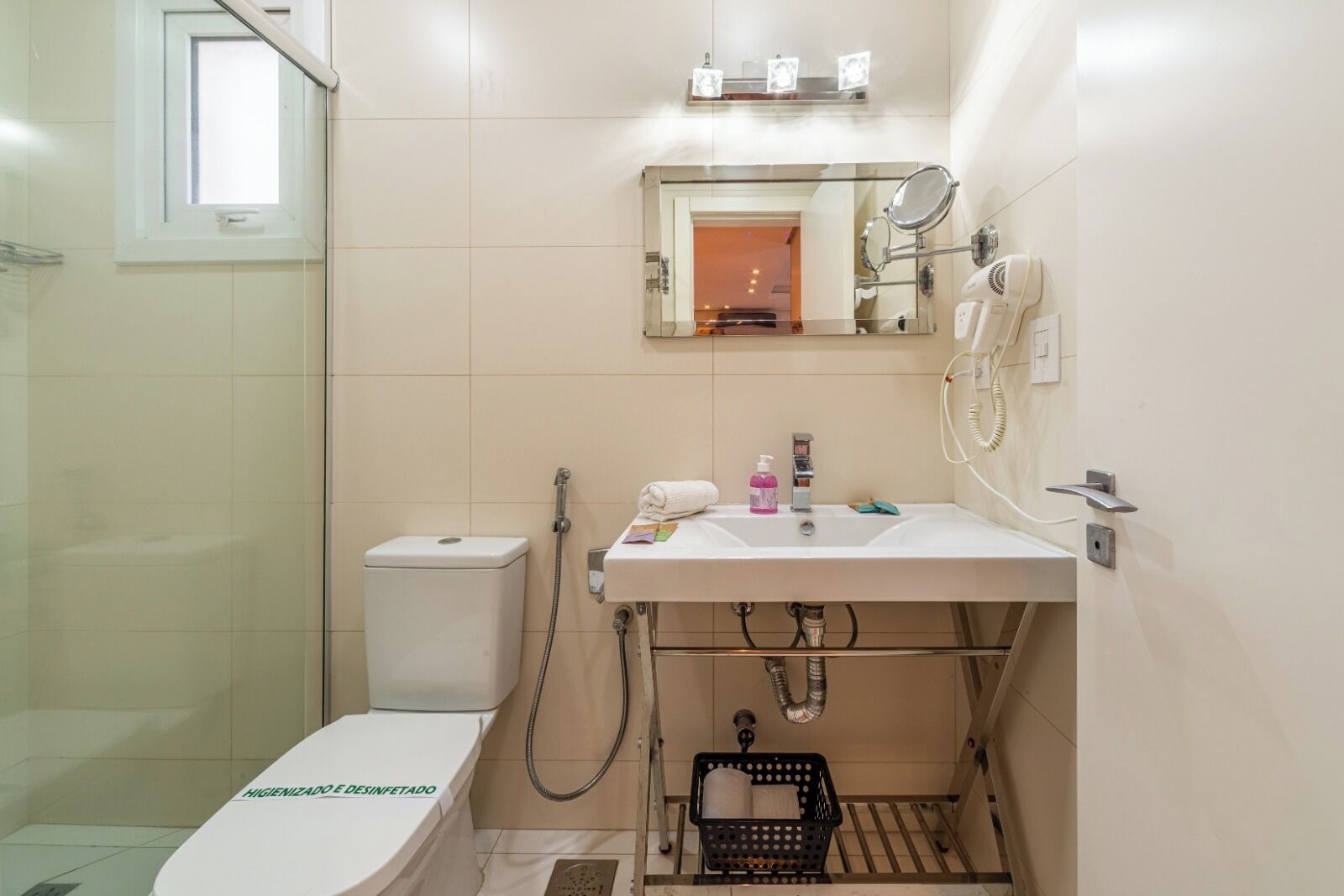 Une salle de bain équipée de toilettes, d’un lavabo, d’un miroir et d’une douche.