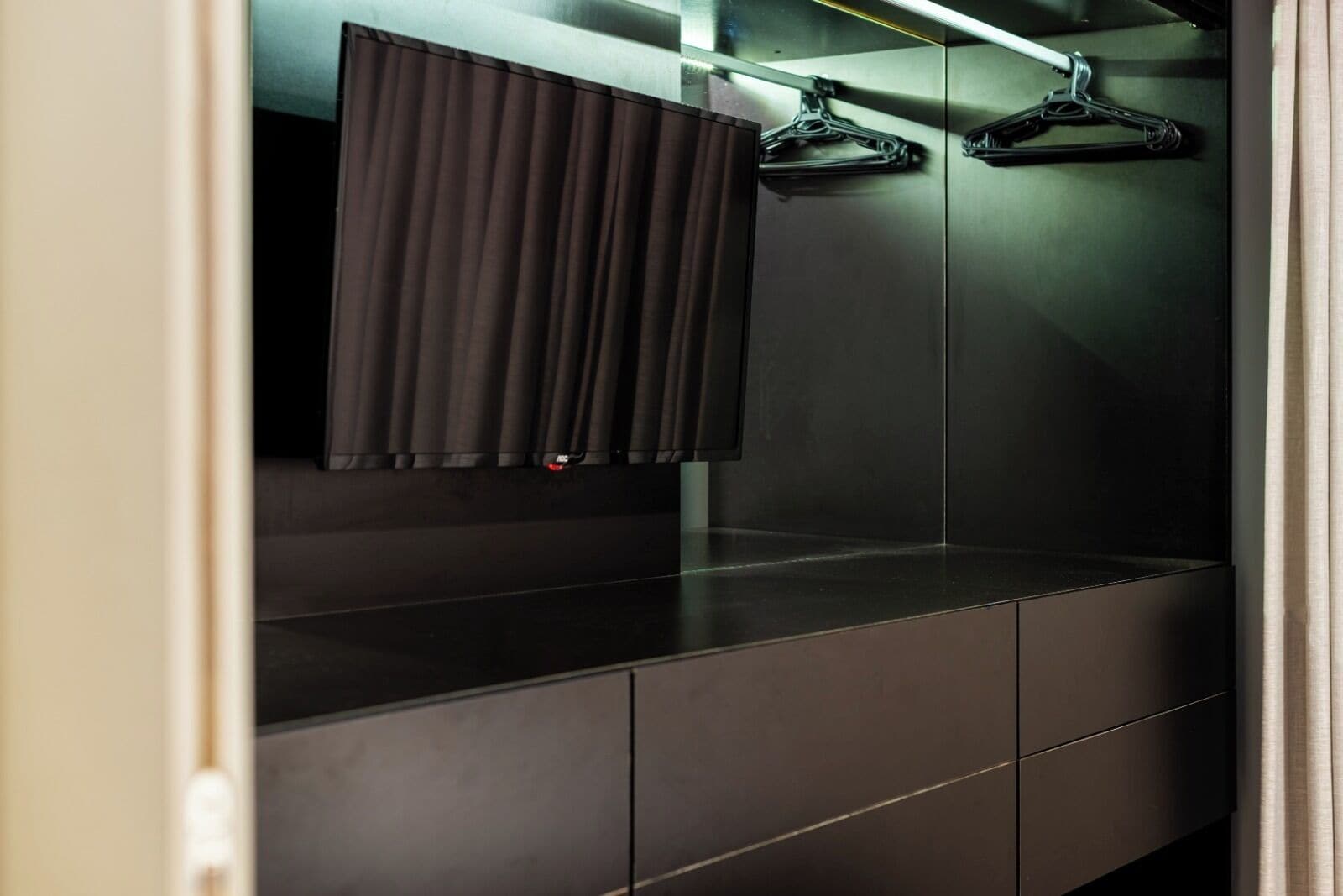 A modern bathroom with a mirror, a towel rack, and a dark-colored vanity.