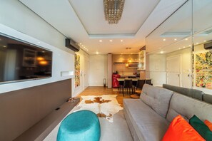 Una sala moderna con un sofá, un reposapiés y un comedor con sillas y una mesa.