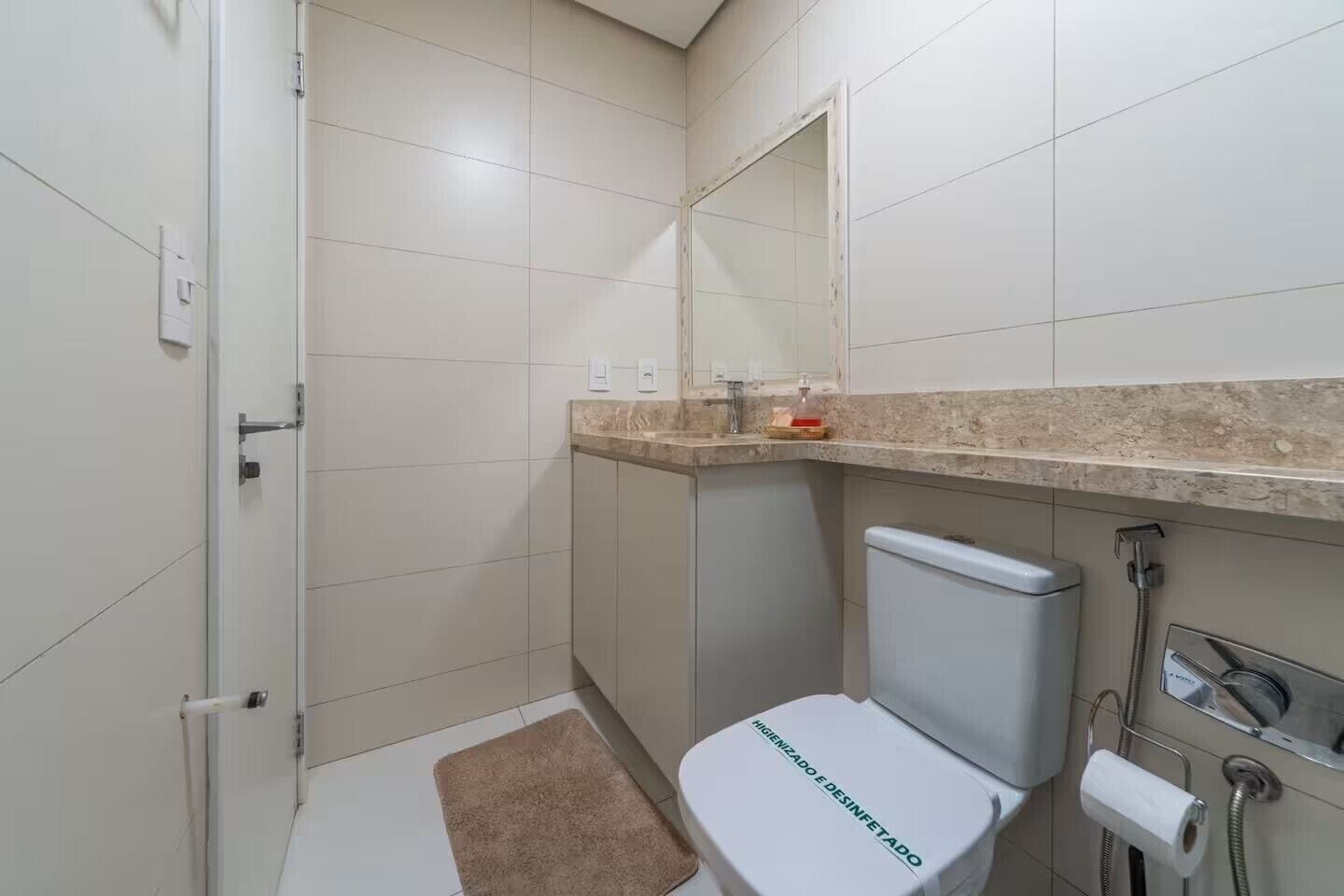 A bathroom with a toilet, a shower, and a sink.