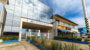A modern building with a glass facade and a sign reading "COSTA AZUL".